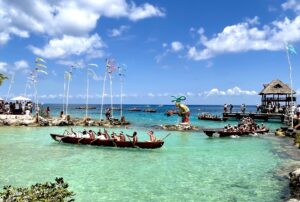 Sacred Mayan Crossing annual reenactment in 2023 showing the fleet of traditional canoes being rowed by people in historic garb arriving to Chankanaab in Cozumel 2023