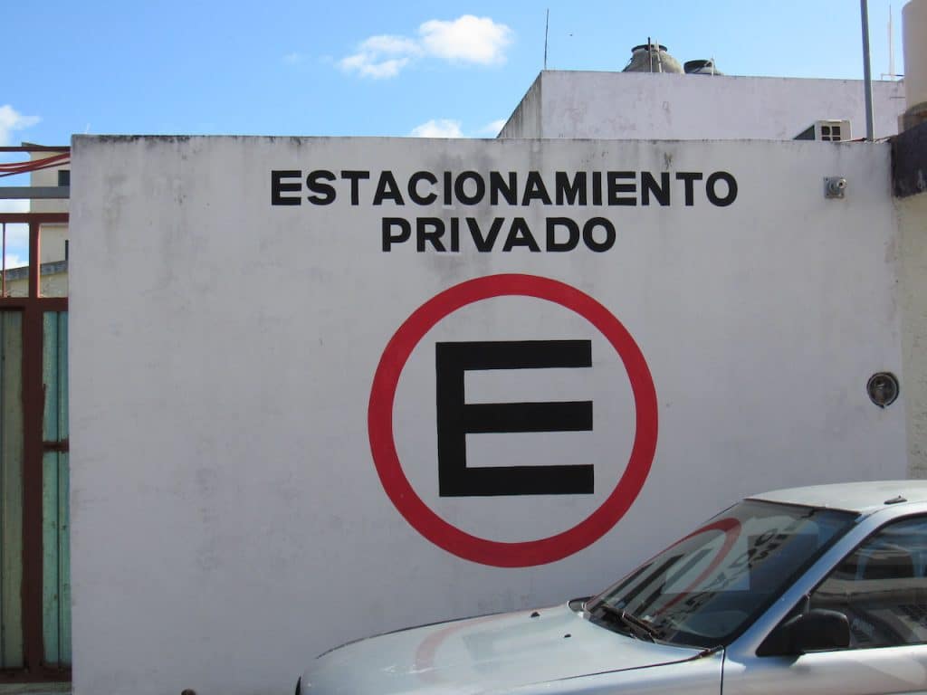 Typical private parking lot signage, hand-painted on white wall in Cozumel