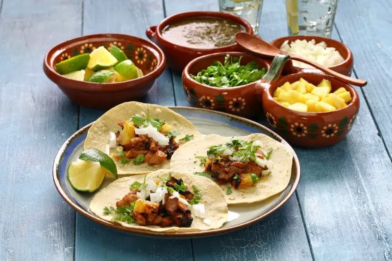 Tacos and typical Mexican taco condiments served up on a table.