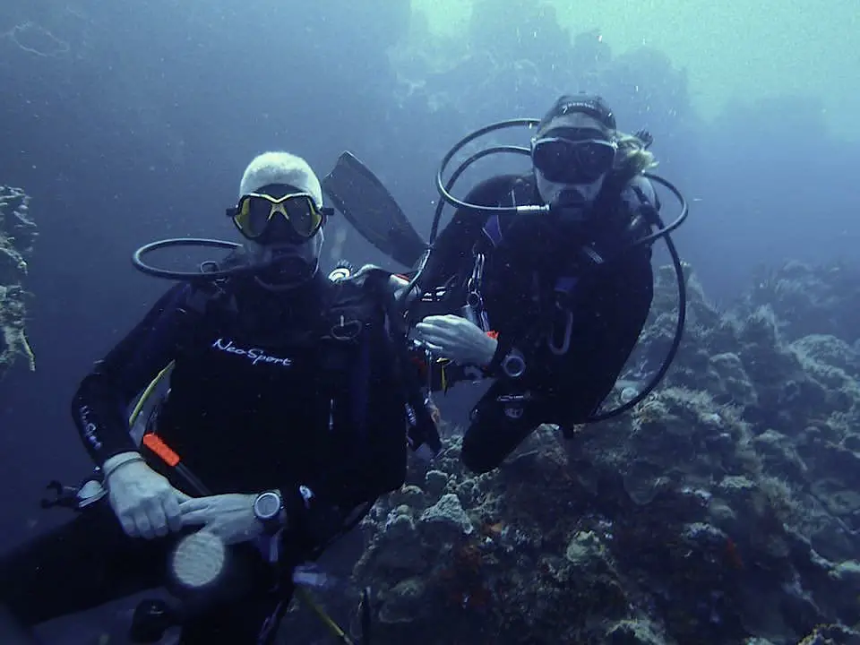 Two divers underwater at Palancar reef in Cozumel Mexico.