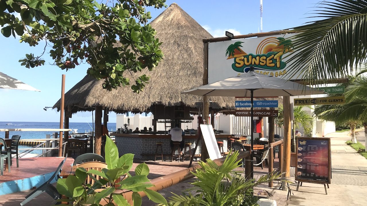 Sunset bar in Cozumel with view of ocean and palapa hut.
