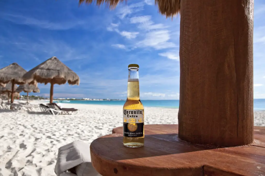 Bottle of Corona beer on sunny Caribbean beach in Mexico.