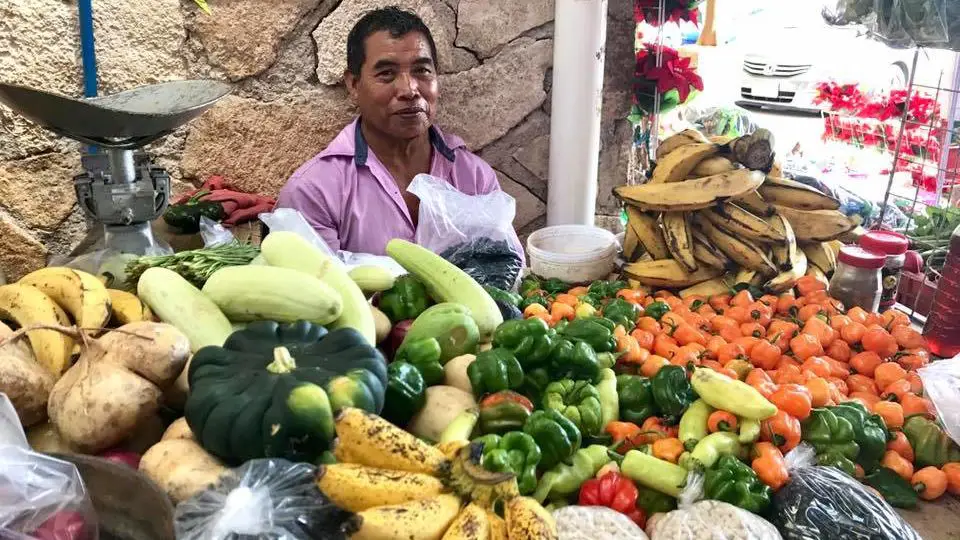 Produce vendor smiling at Cozumel mercado