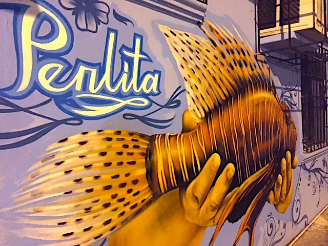 Author's image of La Perlita restaurants facade, with mural of lionfish painted on exterior wall in Cozumel. 