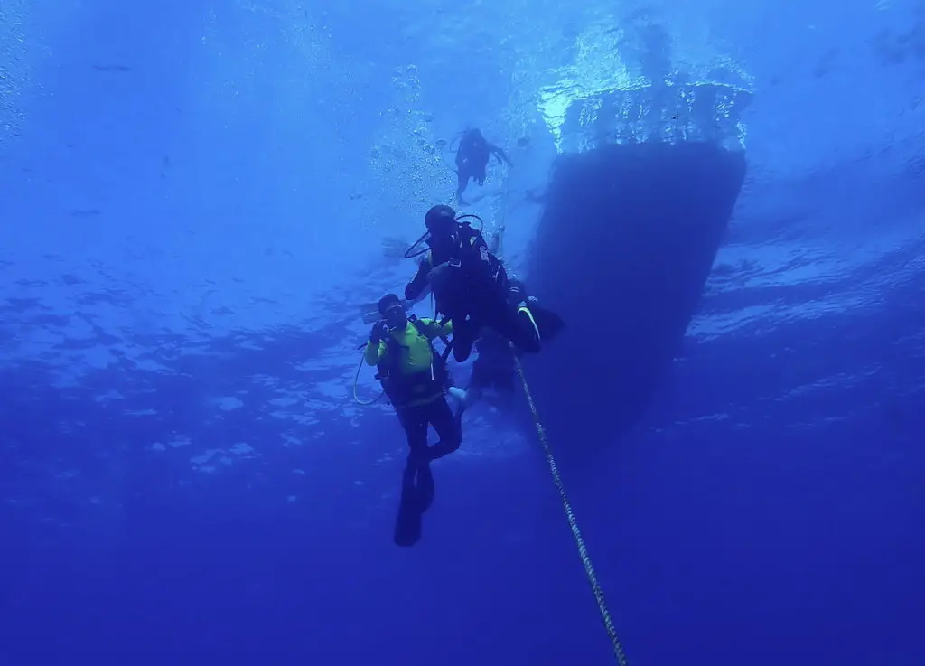 A few divers underwater doing their safety stop after diving the C-53 wreck in Cozumel. 