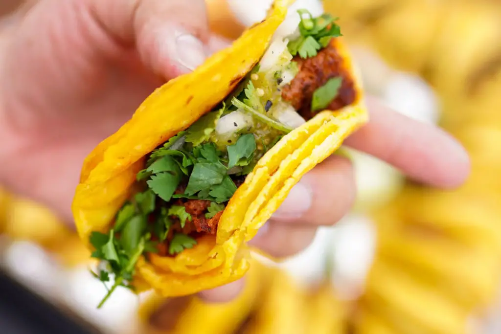 Image from Unsplash of a pastor taco with cilantro and diced onion on small corn tortillas. 