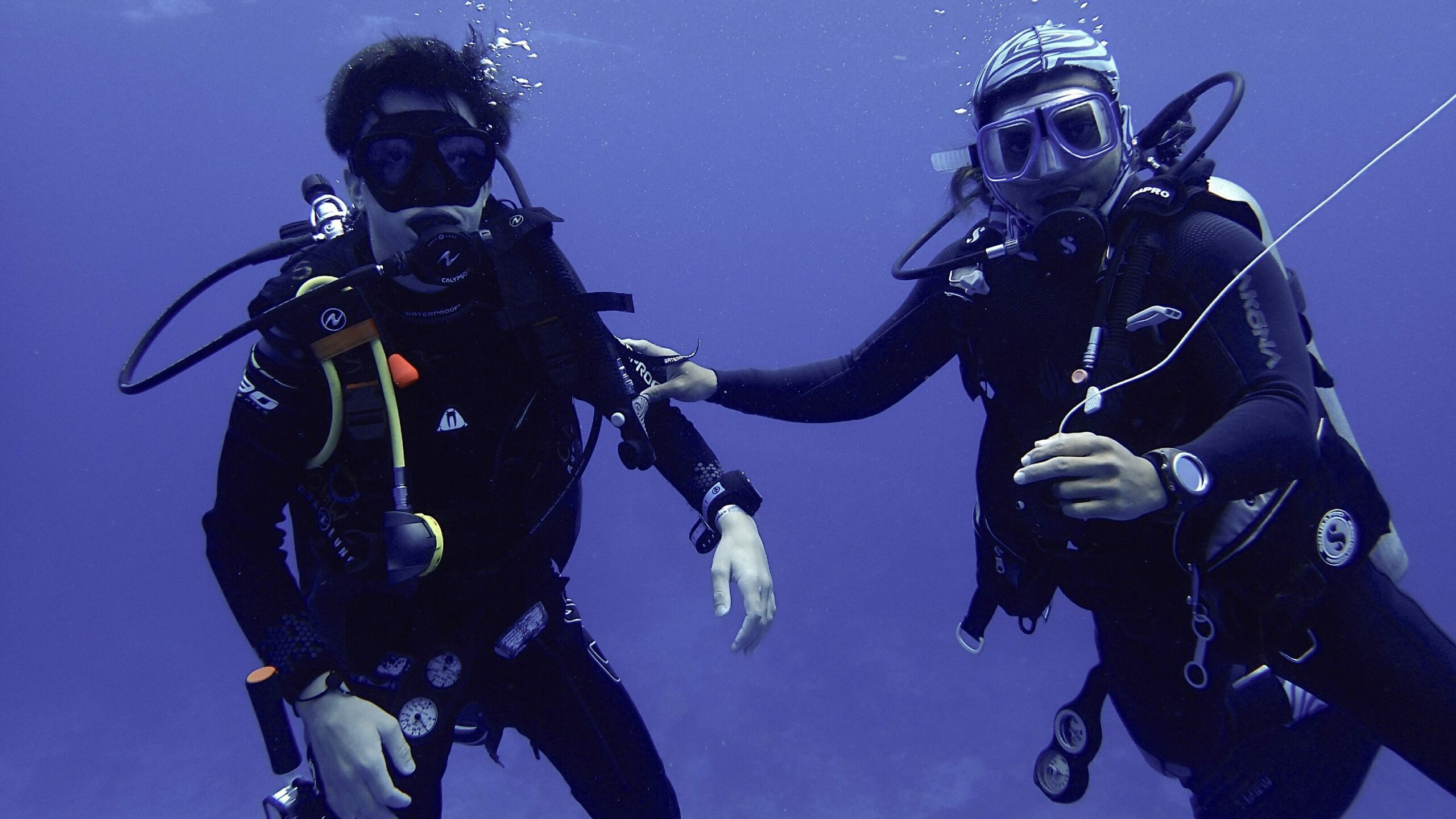Scuba instructor and student in Cozumel, underwater waving for the camera.