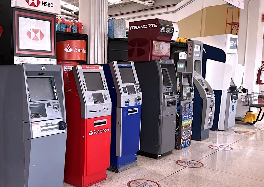 Picture of an array of 7 bank-owned ATM terminals in Cozumel's busy Chedraui supermarket. 