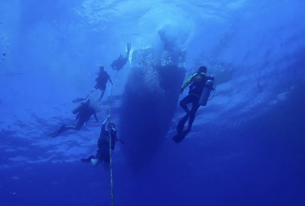 Divers ascending via the mooring line of the C-53 shipwreck dive in Cozumel. 