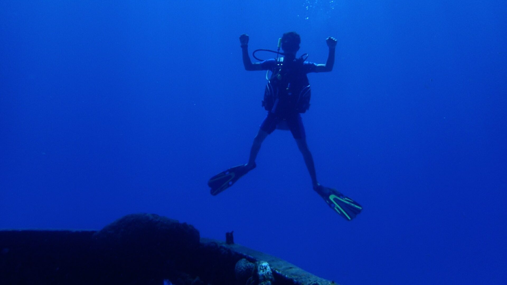 Funny picture of a diver cheering while hovering over the C-53 wreck in Cozumel. 