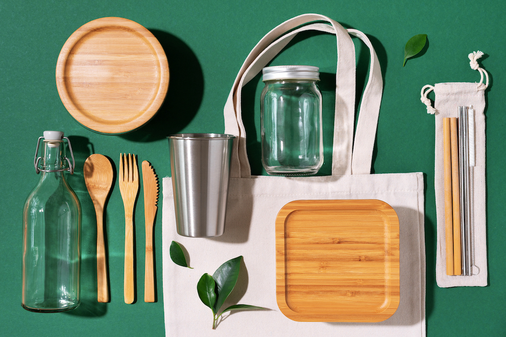 Image of various reusable no-waste containers, like bamboo boxes, metal straws, and glass jars. 