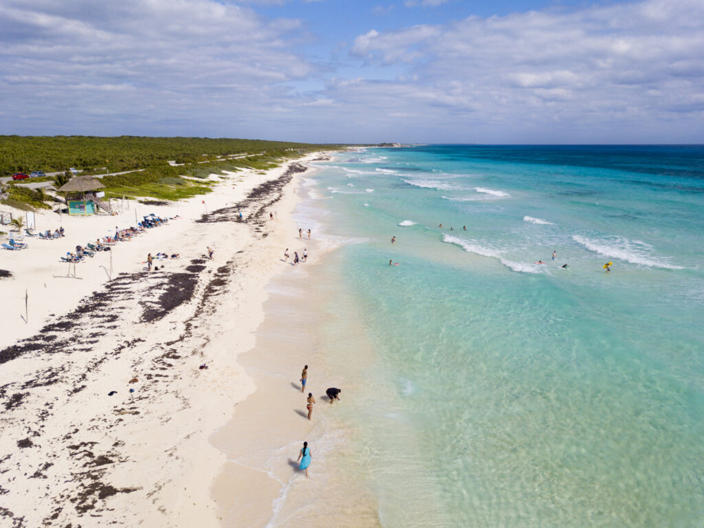 Aerial view of Cozumel's Playa San Martin with blue water and some sargassum along the shore