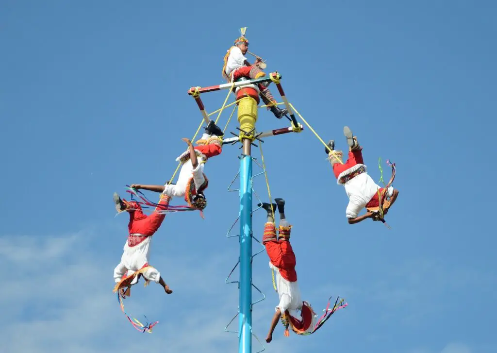 A team of Mexican Voladores during a high-flying performance in traditional garb. 