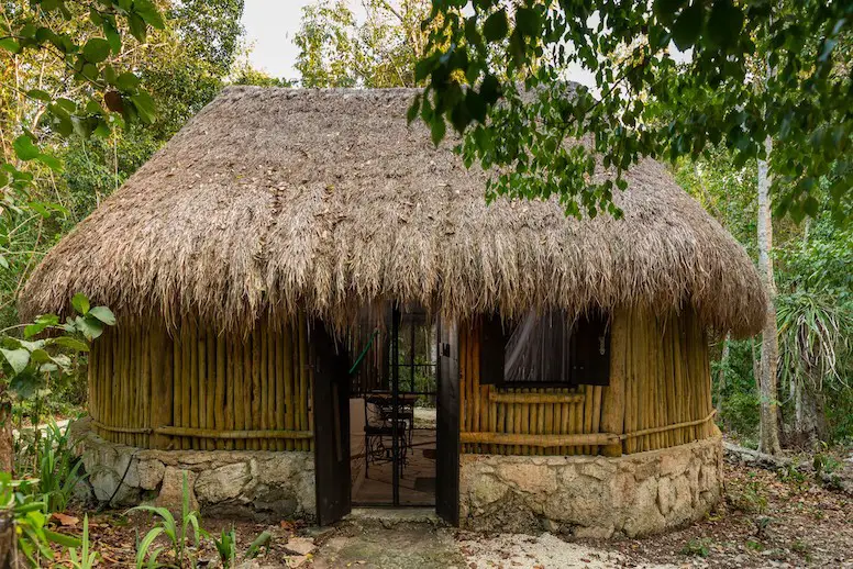 Photo of small thatched-roof cabin accommodations, courtesy of Villa Maya nature reserve in Cozumel. 