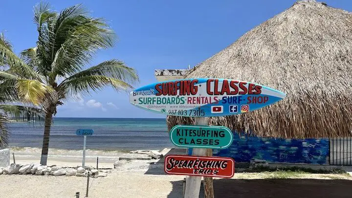 Image of signs for surf lessons, spearfishing trips, and kitesurfing lessons on the other side of Cozumel island in 2023. 